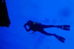 Diver swimming over the wreck of the Jane C. Nikonos V, 2... by Matthew Shanley 